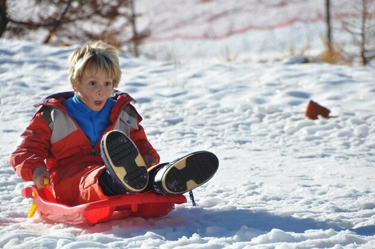 Chłopiec na sankach na śniegu