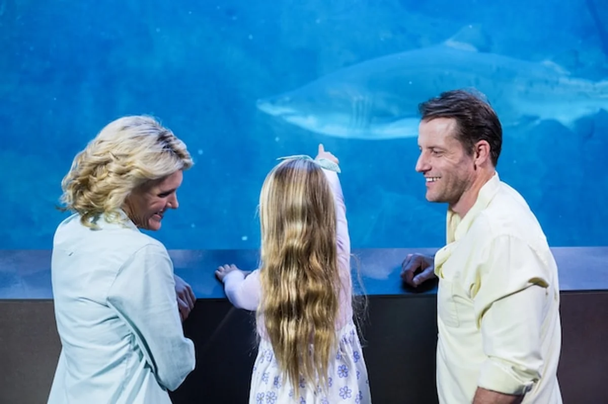 Szczęśliwa rodzina przy akwarium