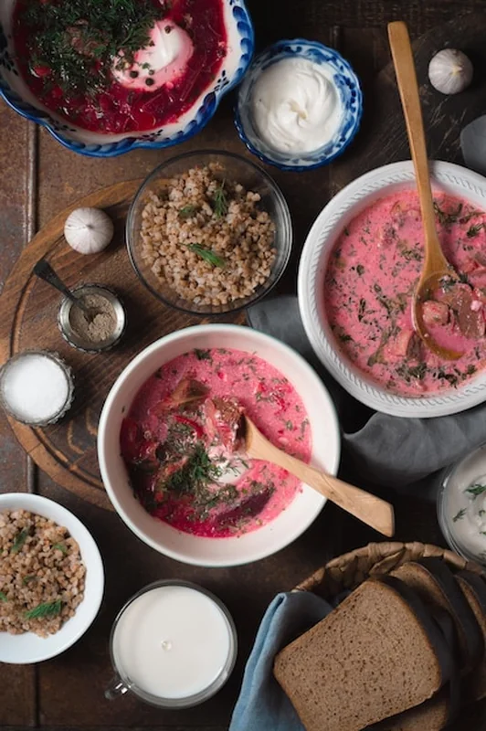 Zupa borowikowa z kwaśną śmietaną, chlebem i mięsnymi ciastami na drewnianym stole