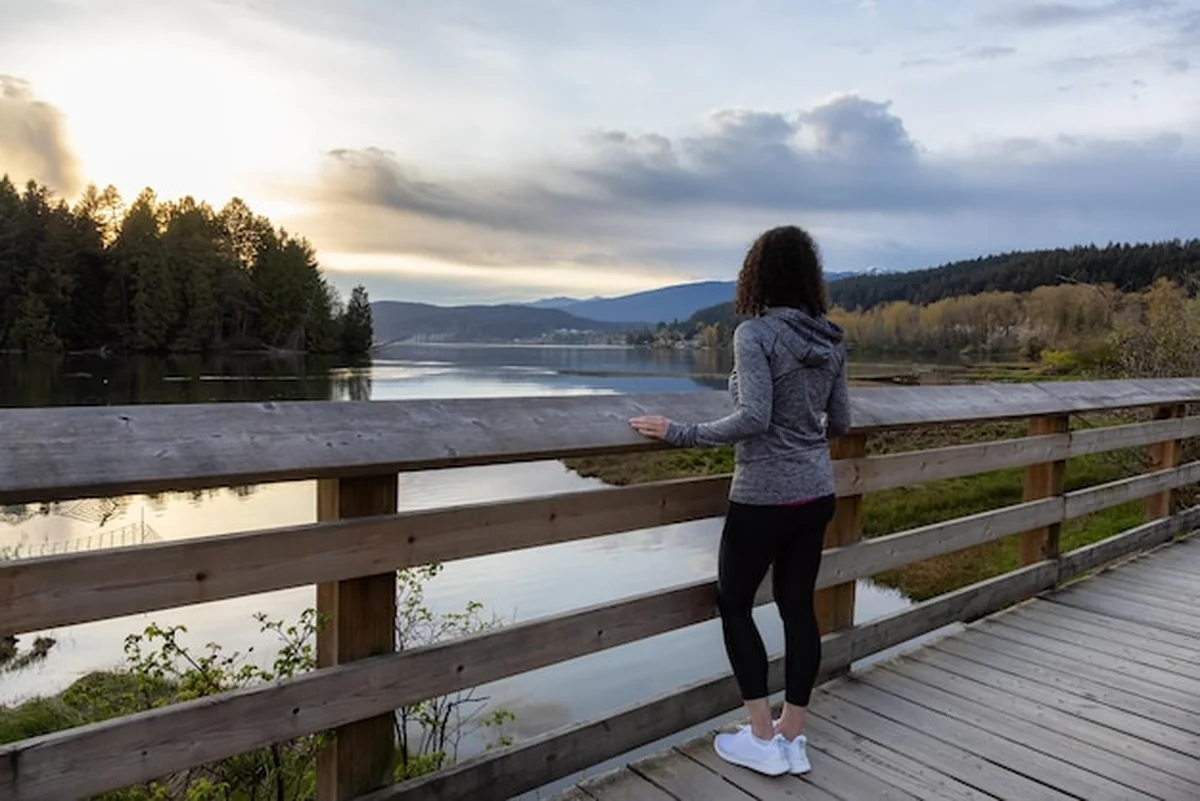 Kobieta spacerująca po drewnianej ścieżce w lesie