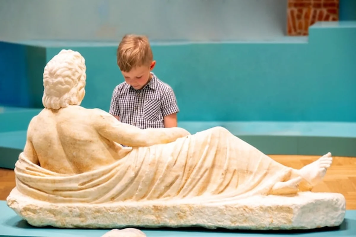 Młody chłopiec ogląda ekspozycję w muzeum