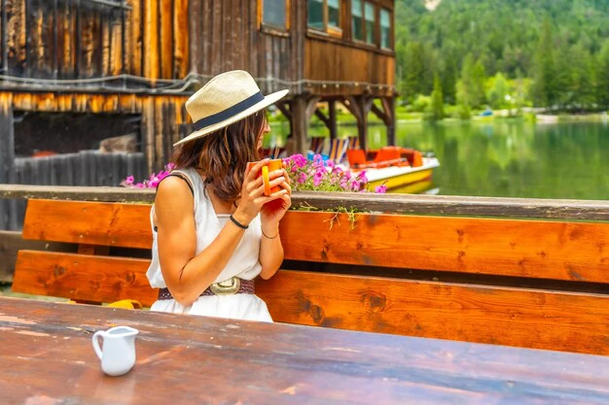 Turysta pije gorący napój nad jeziorem Dobbiaco w Dolomitach