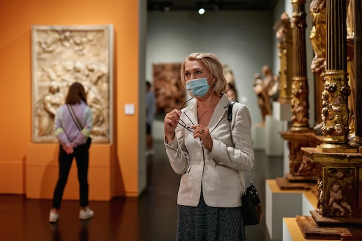 Dojrzałe kobiety oglądają sztukę w muzeum z przewodnikiem
