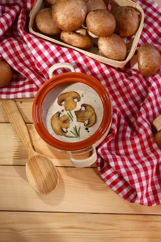 Zupa z grzybów w garnku na serwetce na drewnianym tle
