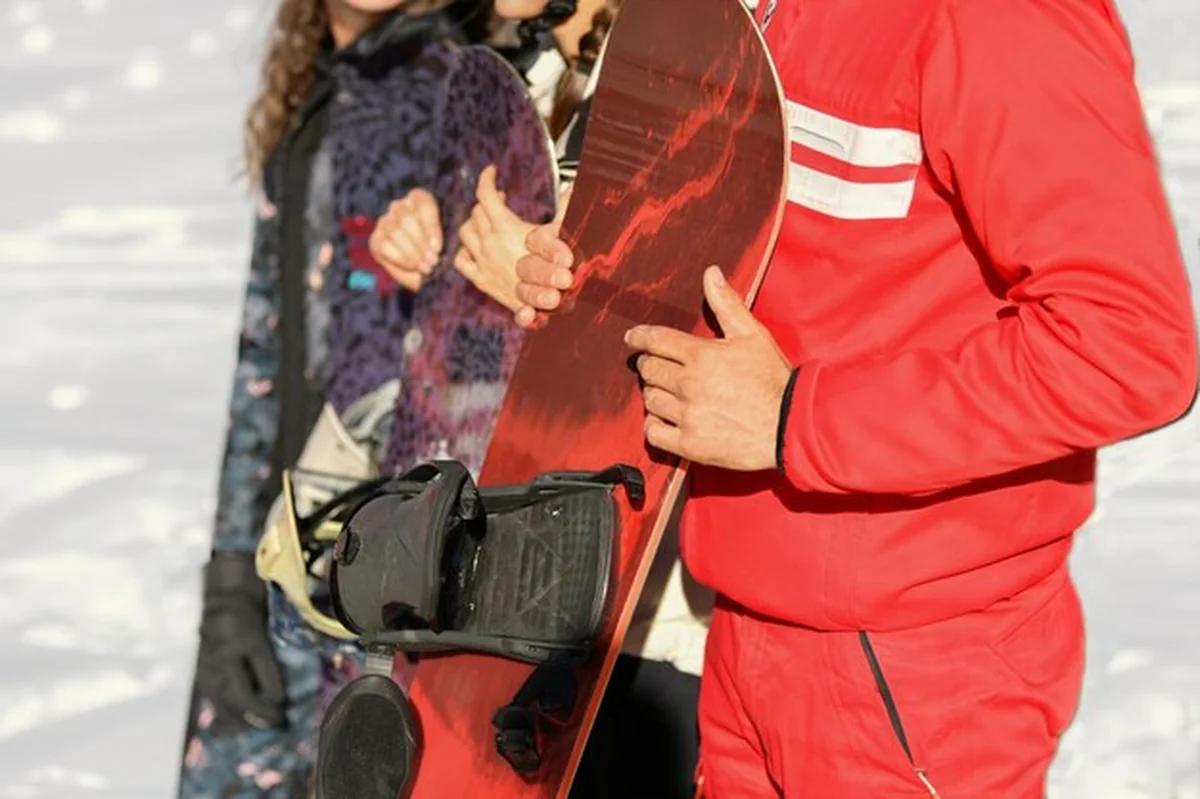 Snowboarder trzymający snowboard w ręku