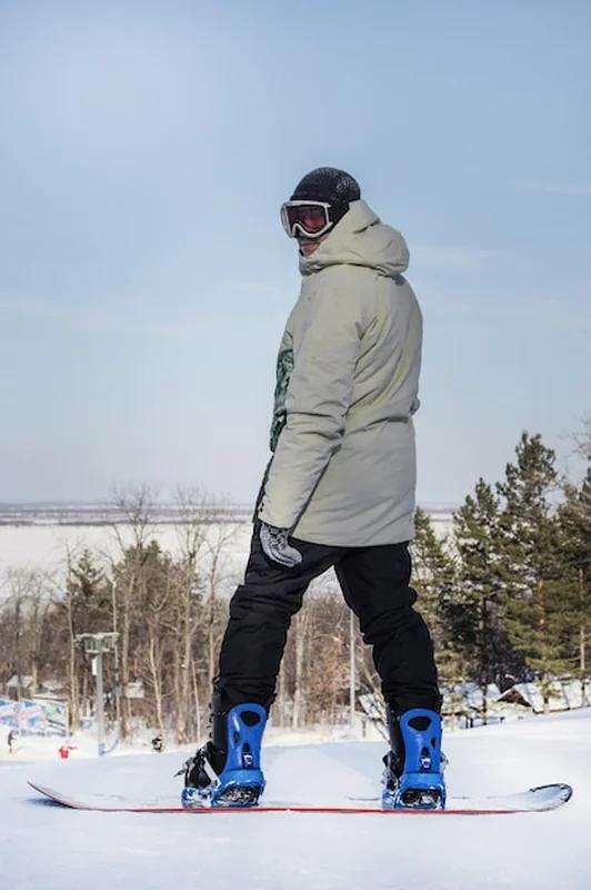 Młody mężczyzna na snowboardzie na szczycie stoku