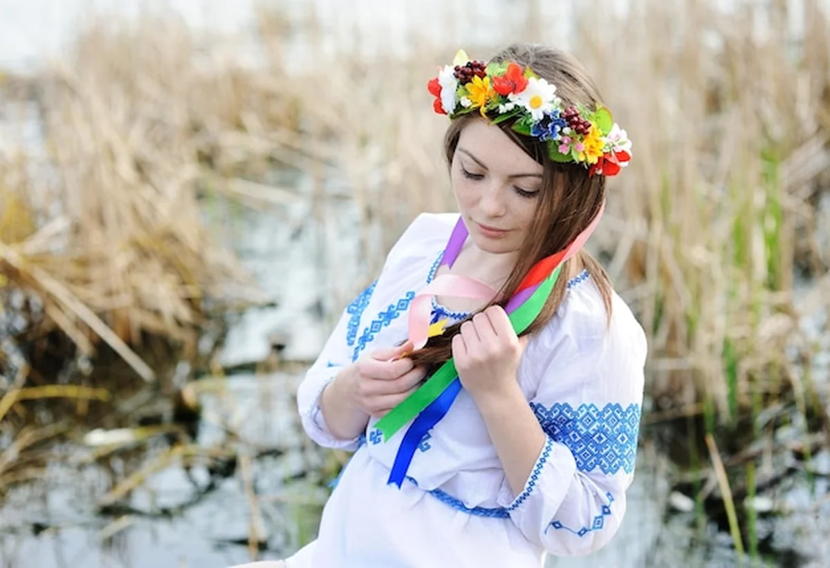 Dziewczyna w ukraińskiej koszuli narodowej i kwiatowym wianku na głowie