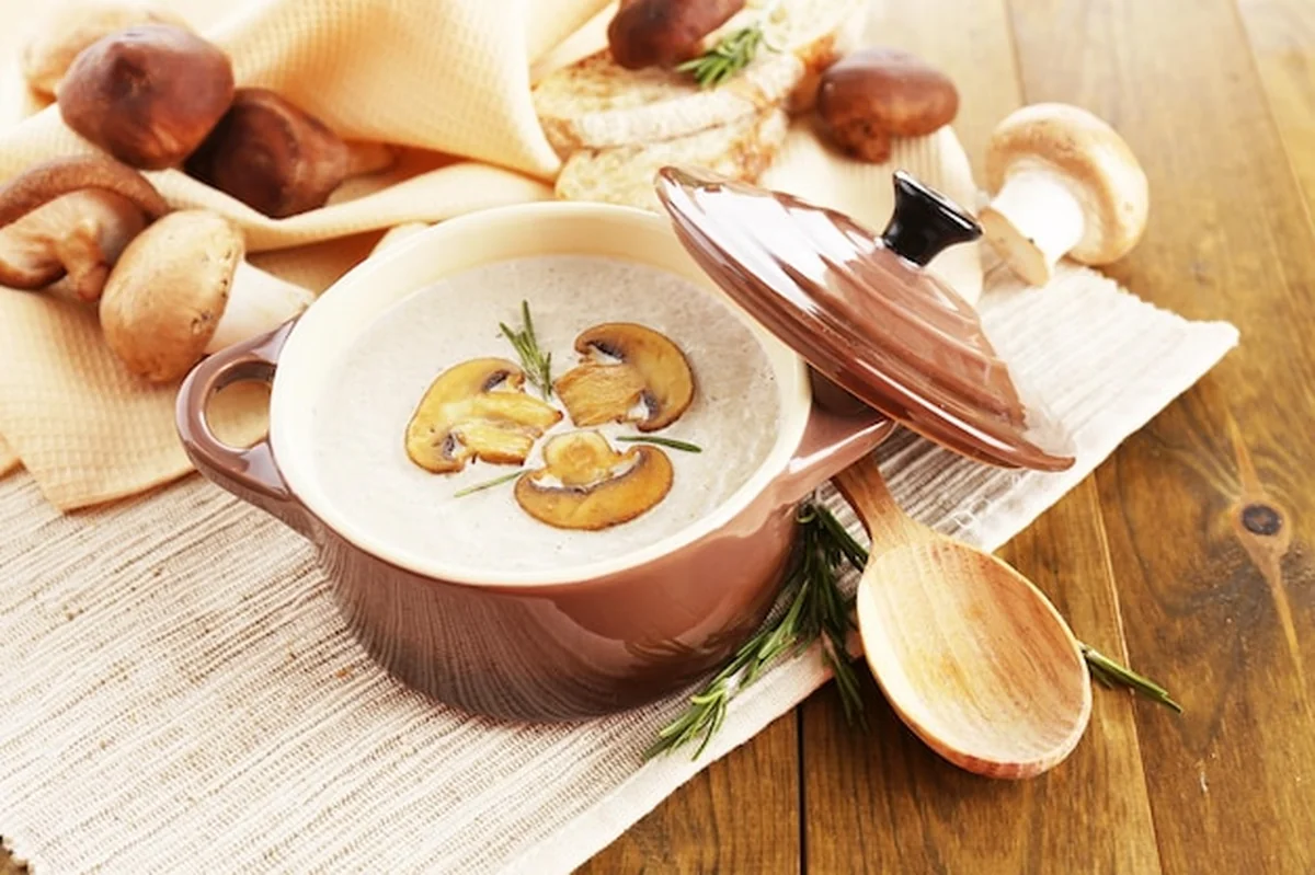 Zupa grzybowa w garnku na drewnianym tle