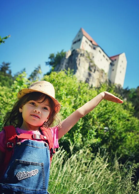 Dziewczyna przed roślinami i fortem patrząca w inną stronę