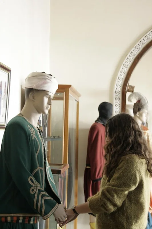 Kobieta dotykająca rąk posągu w muzeum