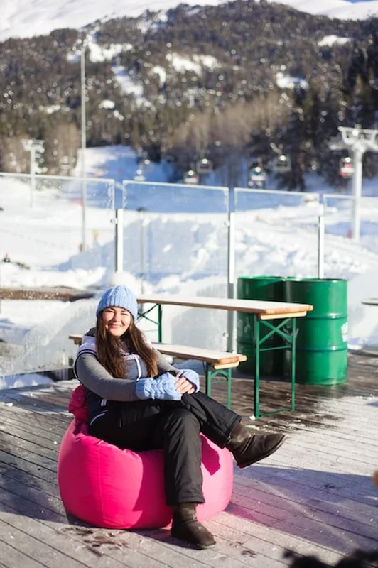 Piękna dziewczyna odpoczywa w ośrodku narciarskim pod górami