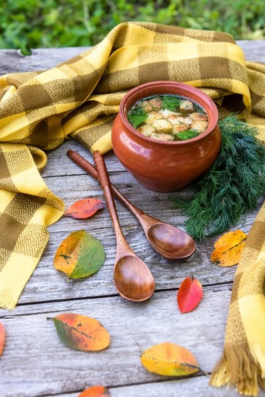Zupa z grzankami w glinianym garnku na drewnianym stole